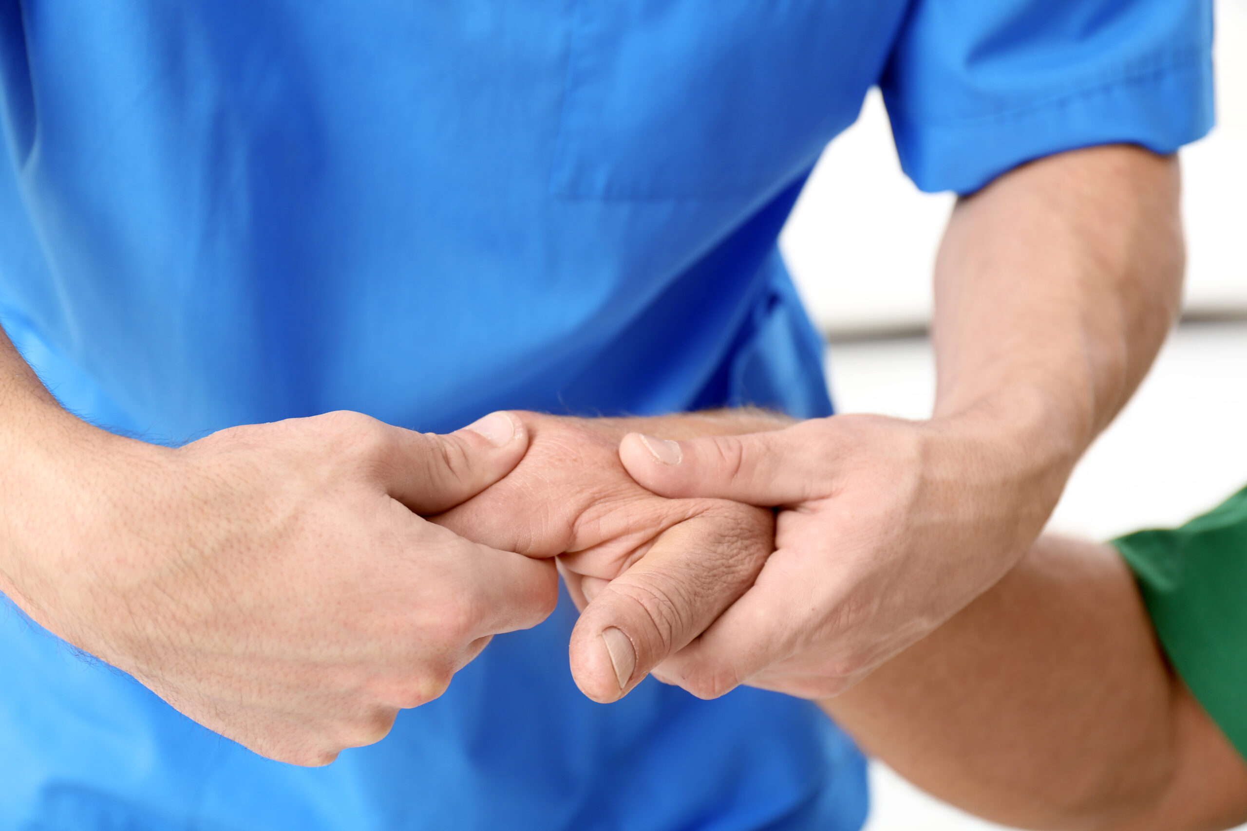 Physiotherapist giving hand massage to senior patient, closeup